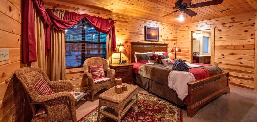 romantic bed and wicker seating in copper pines cabin at beavers bend adventures