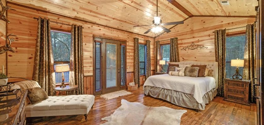 patio in the pines cabin bedroom suite wood walls large bed and chaise lounge in corner