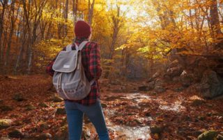 A person hiking on a Broken Bow trail surrounded by Oklahoma fall foliage.