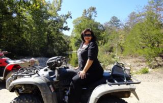 A woman on a four-wheeler/UTV that can be ridden on local trails in Hochatown, Oklahoma.