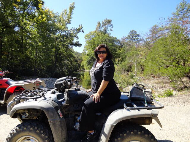 A woman on a four-wheeler/UTV that can be ridden on local trails in Hochatown, Oklahoma.