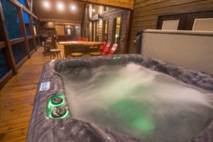 A hot tub on the back deck of an Oklahoma cabin rental in Hochatown.